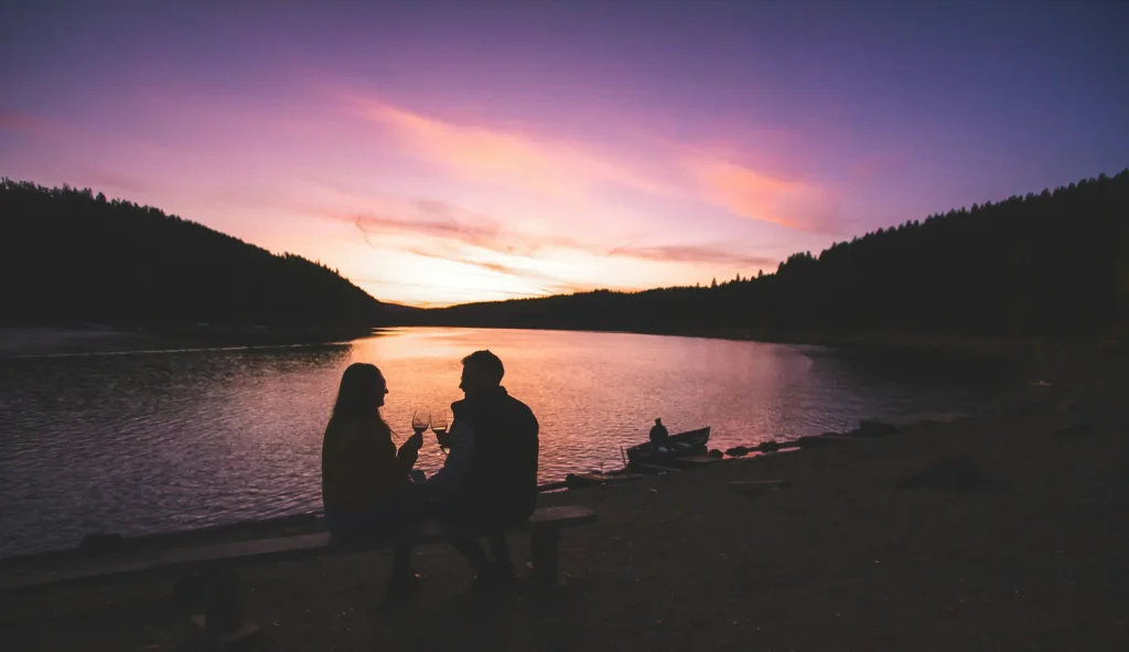 happy couple at sunset with wine glasses