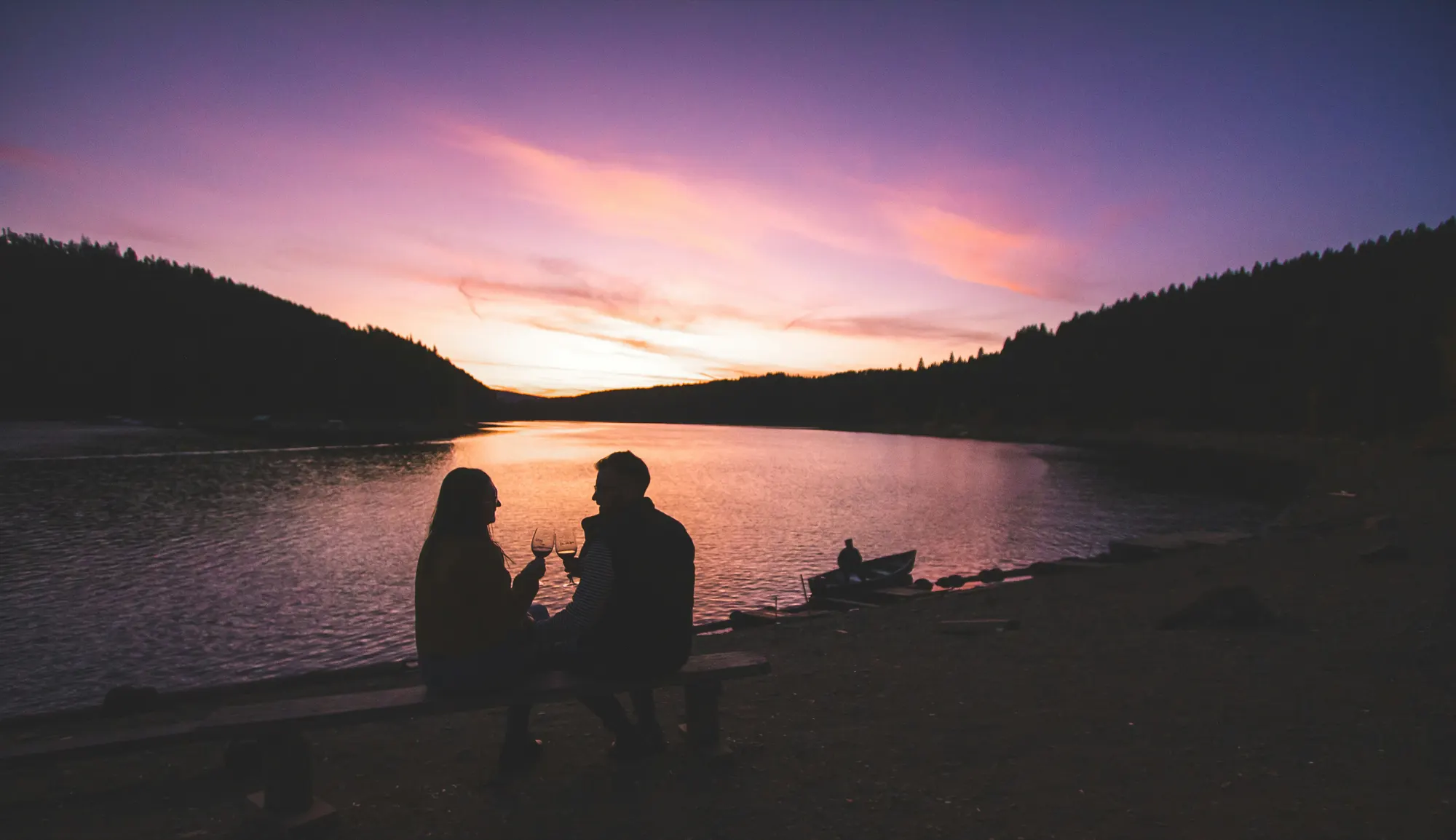 happy couple at sunset with wine glasses